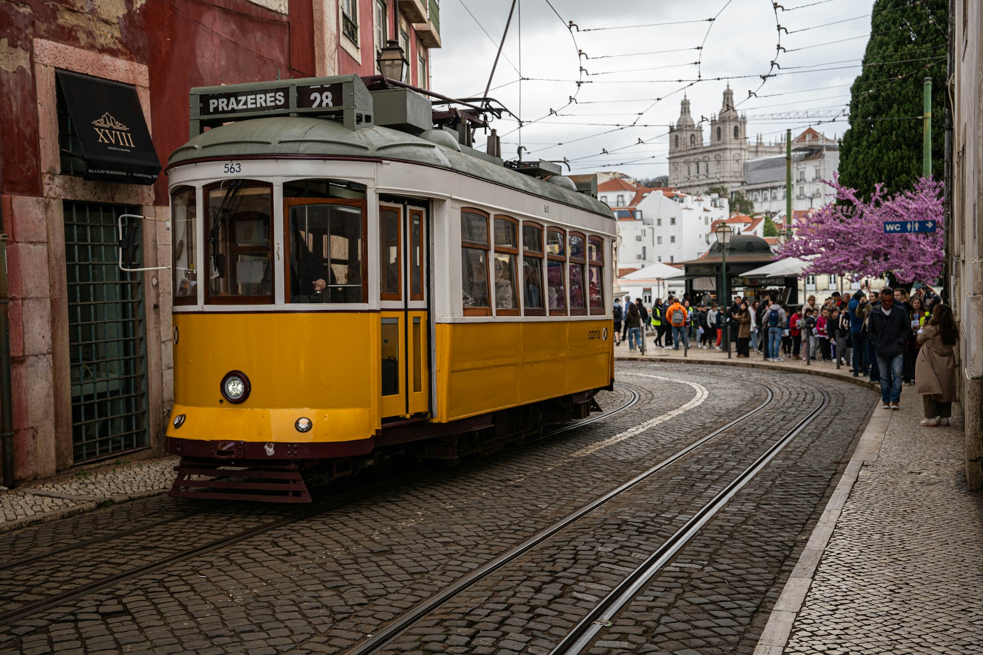 Yellow tram on a historic street in Lisbon, Portugal